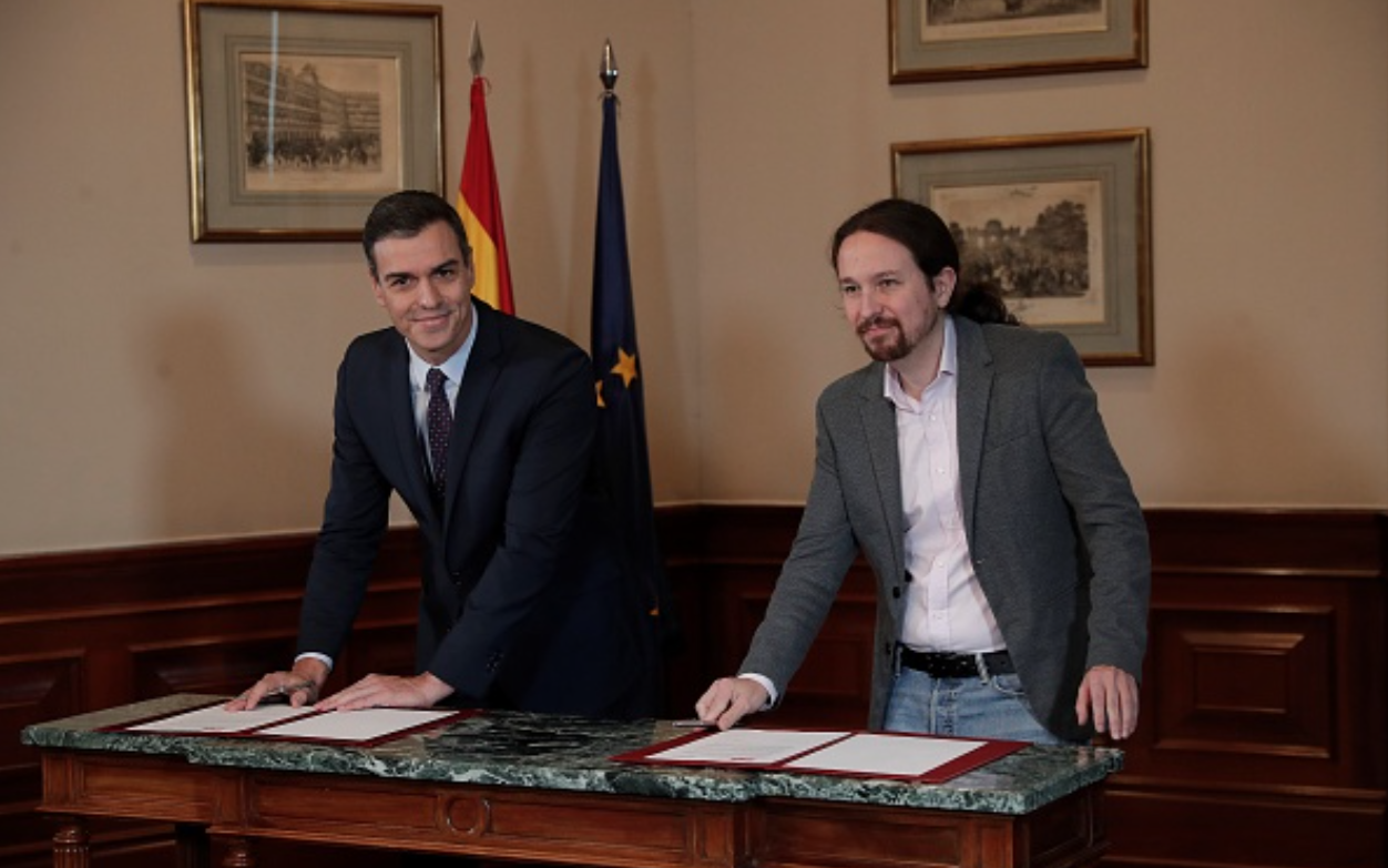 Pedro Sanchez og Pablo Iglesias undertegner foreløpig regjeringsavtale
