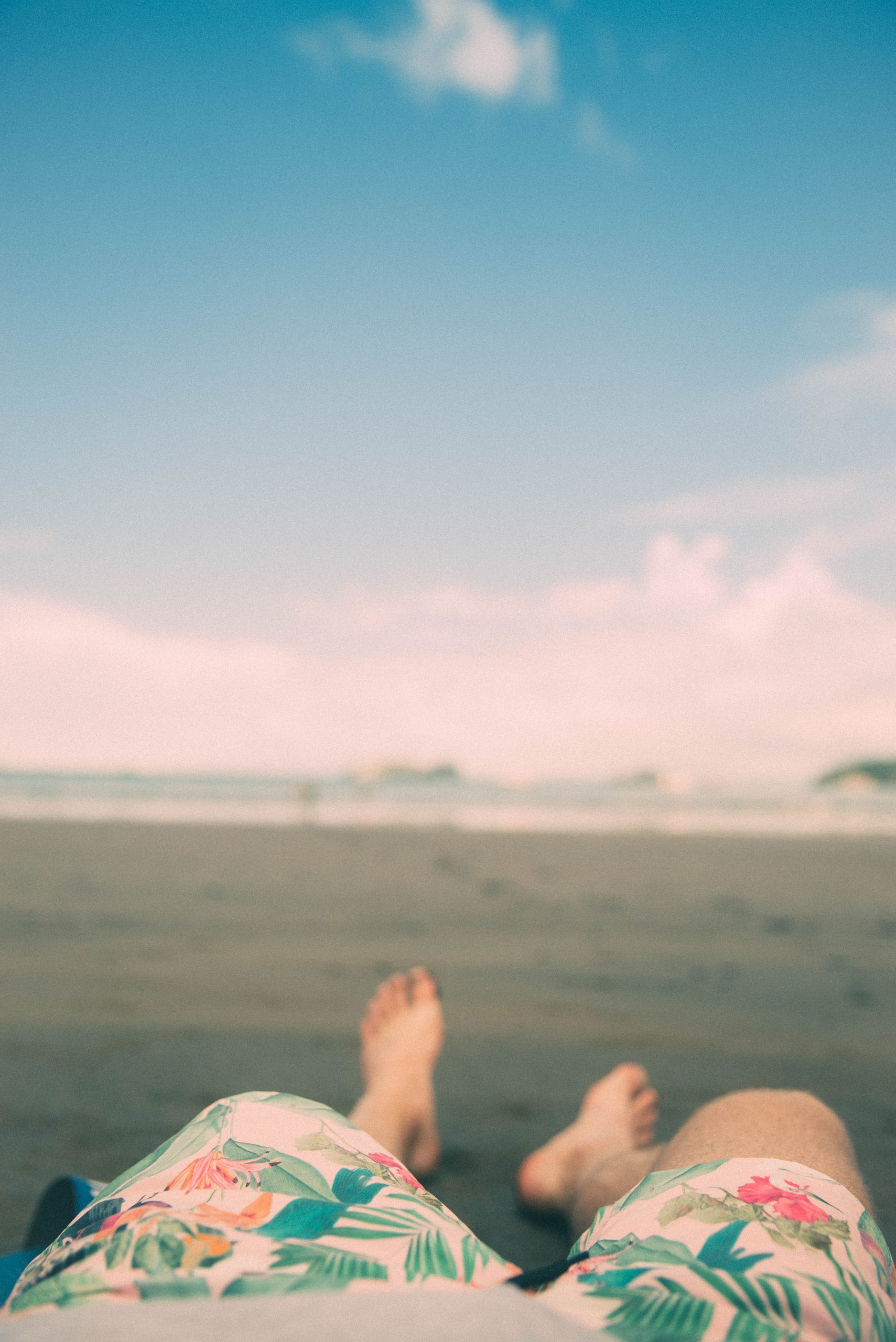 shallow focus photography of person laying on sand